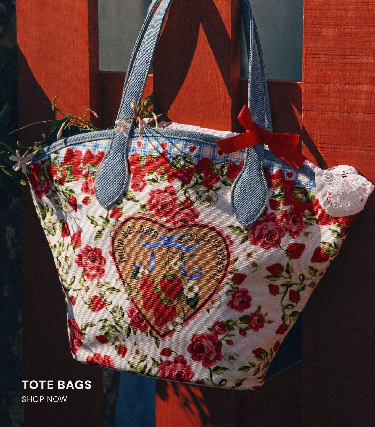 Floral tote bag with heart design and red roses on a dark background