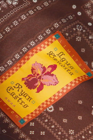 Close-up detail of the Nader Ace Totebag brown print with colorful floral patch.