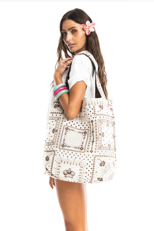 Woman carrying the Nader Ace Totebag in white with brown placement print.