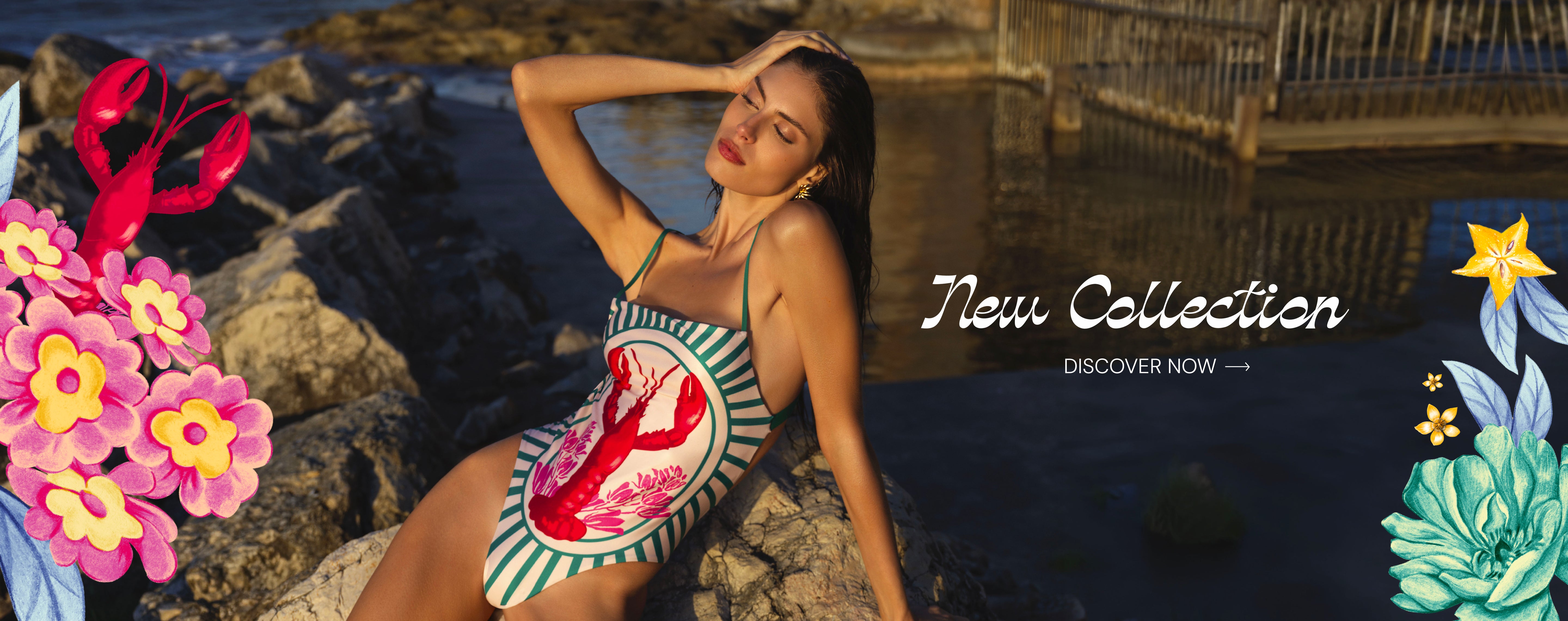 Woman wearing lobster print one-piece swimsuit from luxury new swimwear collection by the coast