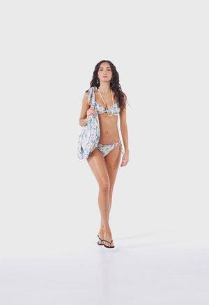 Blue floral bikini featuring a romantic vintage-inspired print on a soft ivory base. Designed with adjustable straps, delicate floral appliqués, and tie-side bottoms for a customizable fit. Explore the fabric details, silhouette, and styling versatility in this product showcase video.