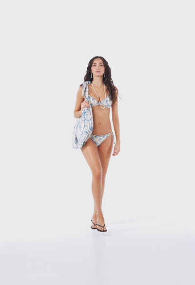Blue floral bikini featuring a romantic vintage-inspired print on a soft ivory base. Designed with adjustable straps, delicate floral appliqués, and tie-side bottoms for a customizable fit. Explore the fabric details, silhouette, and styling versatility in this product showcase video.